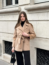 a lady wears a beige wool double-faced coat with black pants